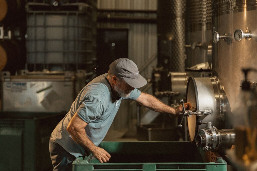 Winemaker adjusting a wine press valve during the 2026 harvest at Rivenburgh Beverage Co.